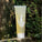 Clarifying Hair Cleanser contains aloe vera, babassu extract and coconut-derived cleansers.
See through bottle with a yellow hue. There is a small leaf design on white on the bottle.
It rests against a tree and leafy background.